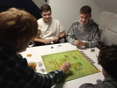 Grupa chłopaków skupiona nad układaniem kafelków w grze Sabotażysta