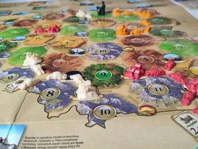 Polska edycja gry Catan rozłożona na stole – widok na planszę z miastami.